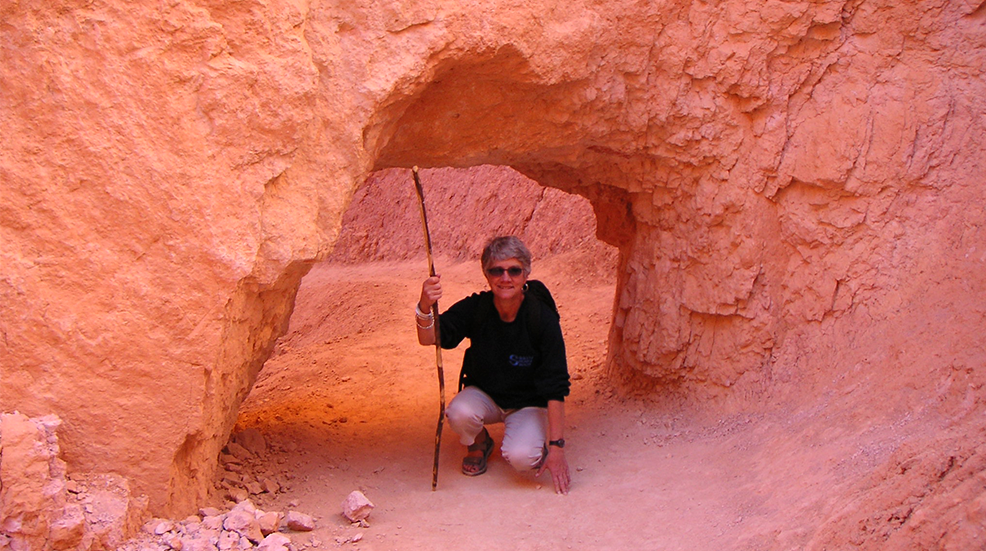 Sue Armstrong posing under a pink rockface